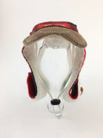 True North Aviator Hat with brown leather-like front bill. Front view of the hat. Hand-made with red plaid fleece fabric with sherpa inside, a hole for each ears, side flap with buttons on and a drawstring under the chin to adjust. The front bill can be used a shield from rain/ snow when it's not flipped back. 